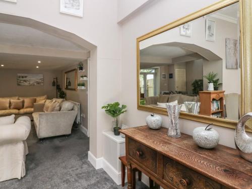 a living room with a mirror and a couch at Clarence House in Dalton in Furness