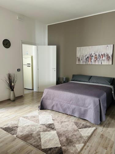 a bedroom with a large bed and a rug at Essential House in Brindisi