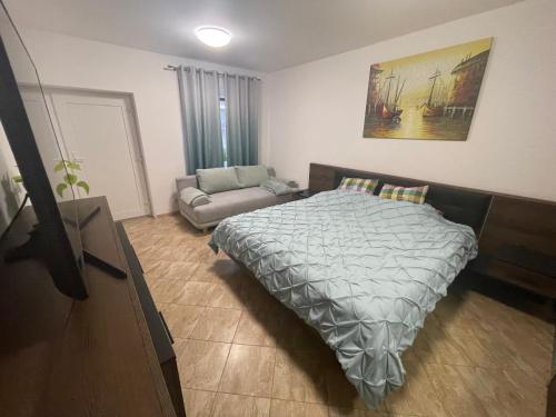 a bedroom with a bed and a couch at Apartmán Pohoda in Břeclav