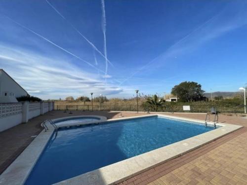 una gran piscina con un cielo azul claro en Apartamento junto al mar con WiFi y piscina, en Sagunto