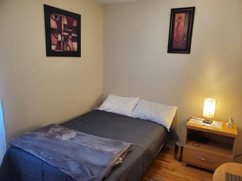 um pequeno quarto com uma cama e uma mesa de cabeceira em Le1226 Apartment em Edmundston