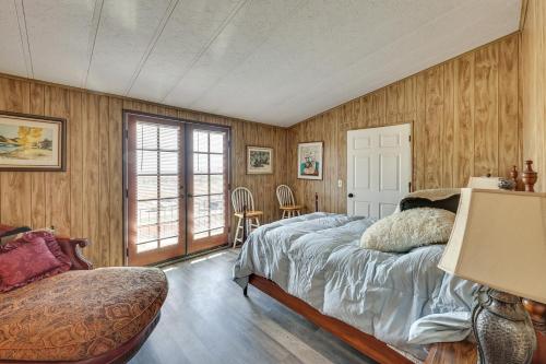1 dormitorio con paredes de madera, 1 cama y ventana en Scenic Perris Rental Home about 9 Mi to Lake Elsinore!, en Perris