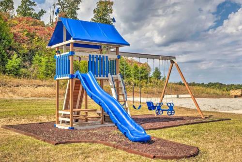 a playground with a blue slide in a yard at Mammoth Cave Cabin Rentals 4 in Cub Run