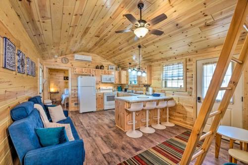 a log cabin kitchen and living room with a blue couch at Mammoth Cave Cabin Rentals 4 in Cub Run