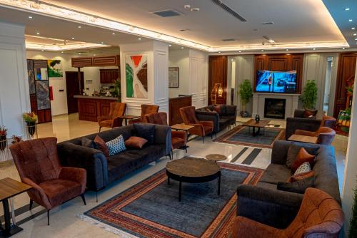 ein großes Wohnzimmer mit Sofas und Fernseher in der Unterkunft Sofia Hotel in Dohuk