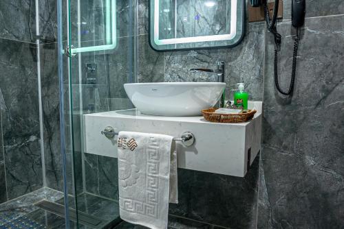 a bathroom with a sink and a glass shower at Sofia Hotel in Duhok