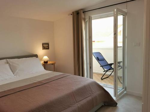 a bedroom with a bed and a sliding glass door with a chair at Paradiso Marino in Scalea
