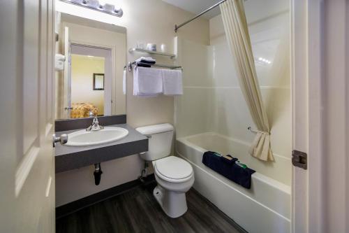 Canadas Best Value Inn Fort St John في فورت سانت جون: حمام مع مرحاض ومغسلة وحوض استحمام