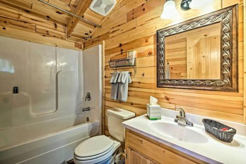 a bathroom with a toilet and a sink and a mirror at Mammoth Cave Cabin Rentals 1 in Cub Run