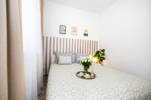 ein Schlafzimmer mit einem Bett mit einer Blumenvase darauf in der Unterkunft ALURE RESIDENCES 2 & 24h self check-in with garage in Banská Bystrica