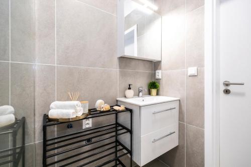 uma casa de banho com um lavatório e um espelho em ALURE RESIDENCES 2 & 24h self check-in with garage em Banská Bystrica