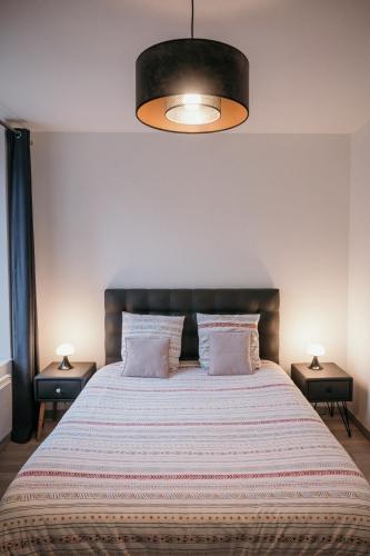 une chambre avec un grand lit avec deux tables de nuit dans l'établissement La suite Delahaye, à Charleville-Mézières