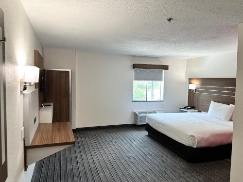 a hotel room with a bed and a window at Ramada by Wyndham Lithia Springs Atlanta in Lithia Springs