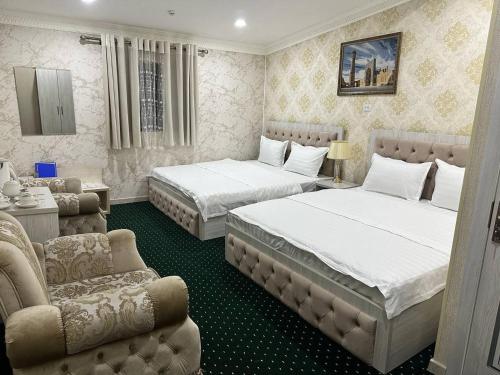 um quarto com 2 camas, um sofá e uma cadeira em SEMURG HOTEL em Tashkent
