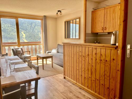 une cuisine et un salon avec une table et des chaises dans l'établissement VAUJANYLOCATIONS - LA FARE 30, à Vaujany