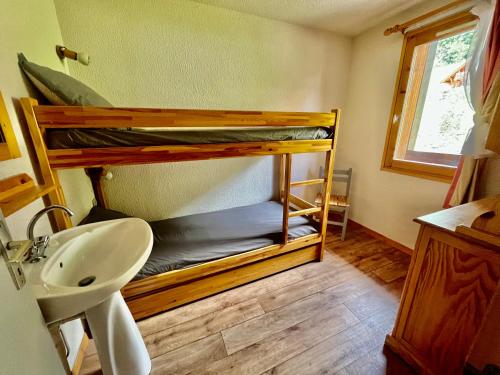 La salle de bains est pourvue de 2 lits superposés et d'un lavabo. dans l'établissement VAUJANYLOCATIONS - LA FARE 30, à Vaujany
