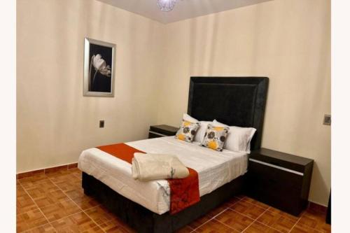 1 dormitorio con 1 cama con cabecero negro en Viñedos y Peña - La Gladiola, en Ezequiel Montes