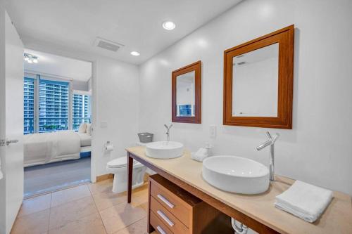 y baño con 2 lavabos, aseo y espejo. en Gorgeous Bay & City view condo in Brickell with Free SPA, en Miami