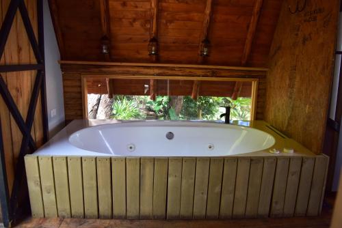 a large bath tub in a room with a window at Glamping con jacuzzi cerca a Medellin in Guarne