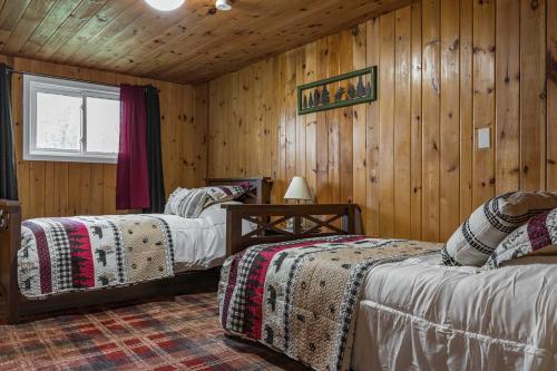 - 2 lits dans une chambre dotée de murs en bois dans l'établissement Waterfront Lake Michigan Hideaway Private Beach!, à Stephenson