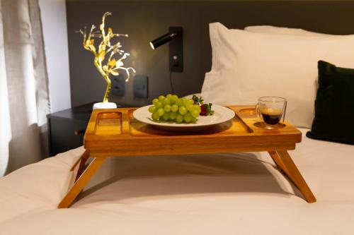 a table with a plate of grapes and a glass of wine on a bed at Flat 1111 WCT Berrini Brooklin in Sao Paulo