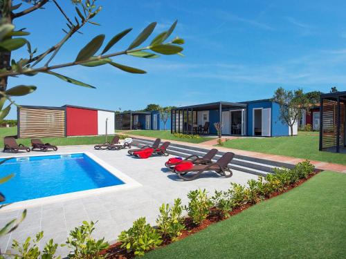 un patio trasero con piscina y una casa en Modern chalet with 2 bathrooms and a veranda 16km from Umag, en Novigrad Istria