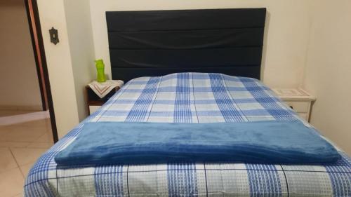 - un lit bleu et blanc dans une chambre dans l'établissement Casa do Roberto, à Jaraguá do Sul