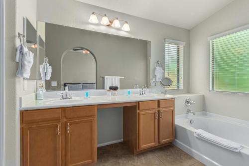 a bathroom with two sinks and a tub and a large mirror at Serenity Haven with Private Pool in Gilbert in Queen Creek