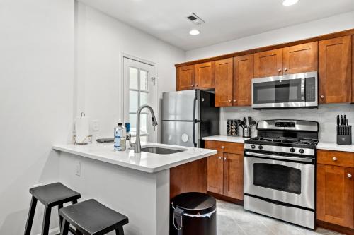 a kitchen with wooden cabinets and stainless steel appliances at The Payne House Old Town, Metro, Free Parking in Alexandria