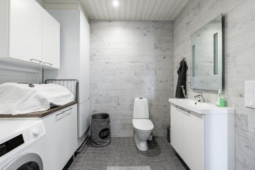 Un baño blanco con inodoro y lavabo. en Vitosjussi, en Hämeenlinna