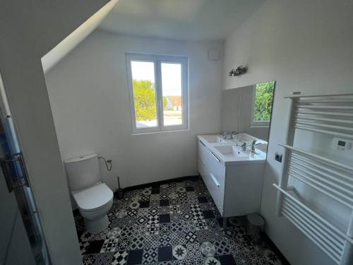 a bathroom with a toilet and a sink and a window at Le château d’eau in Bresles