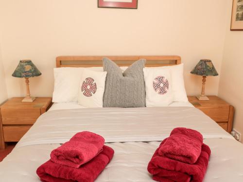 a bedroom with two red towels on a bed at Simonside Apartment in Morpeth