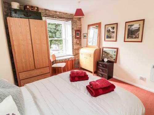 a bedroom with a bed with two red pillows on it at Simonside Apartment in Morpeth