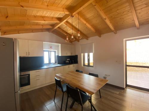 a large kitchen with a wooden table and chairs at Pigi Fotos House in Piyí