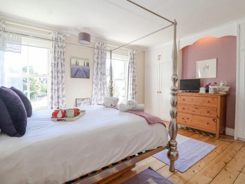 a bedroom with a large bed and a dresser at Green Gate Cottage in Southwold