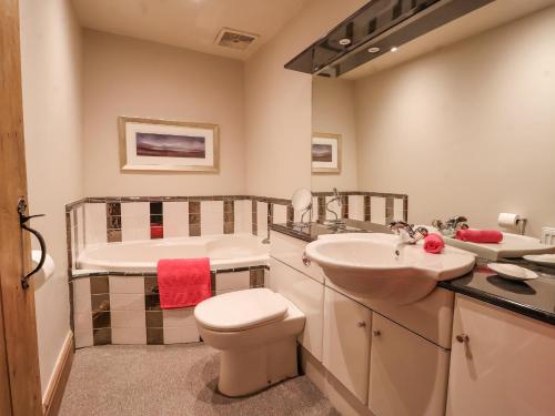a bathroom with a tub and a toilet and a sink at Bay Horse Farm in Skipton