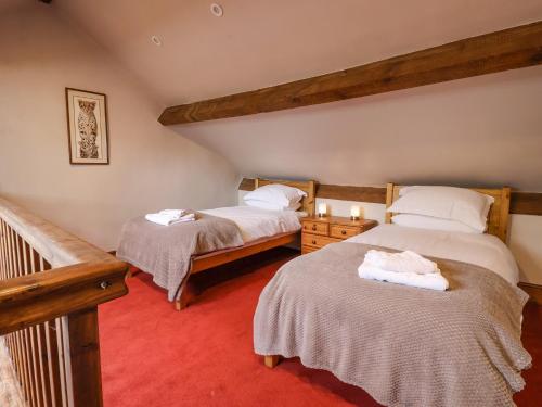 a bedroom with two beds and a staircase in a room at Bay Horse Farm in Skipton