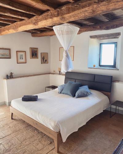 a bedroom with a large bed with blue pillows at Villa Gioietta in Strada