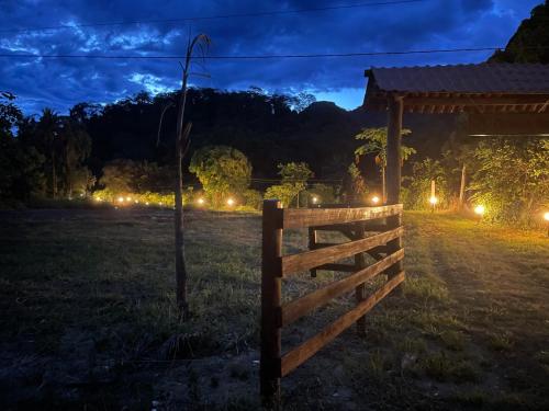 a fence in a field at night with lights at Chácara da Tuia in Estancia do Castello