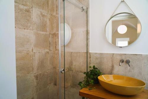 uma casa de banho com um lavatório e um espelho. em Palazzo Lorizzo - nel CUORE di OSTUNI em Ostuni