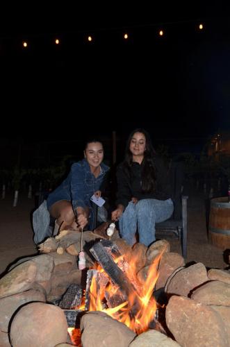 a couple of people sitting around a fire at Sol del Valle in Valle de Guadalupe