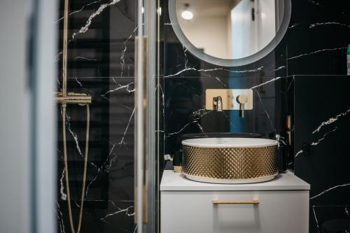 a bathroom with a sink and a mirror at Nocosfera Apartament Premium Ogrodowy II in Kalisz