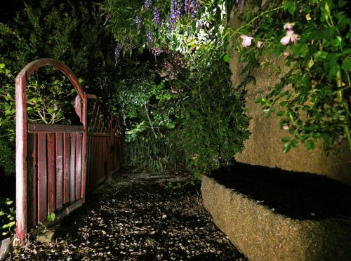 a garden with a red fence and some flowers at ROSA XVI - Garden Guest House in Vilar Torpim
