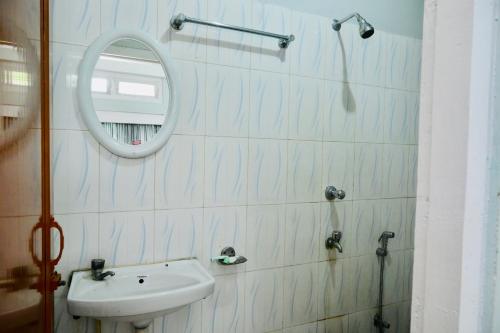 a bathroom with a sink and a mirror at Namaskar Lodge and Homestay in Guwahati