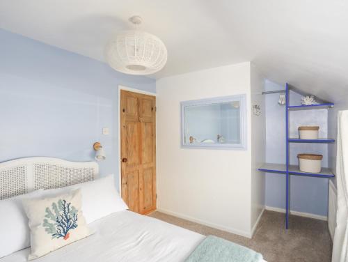 1 dormitorio con cama blanca y estanterías azules en 12 Brynffynnon en Y Felinheli