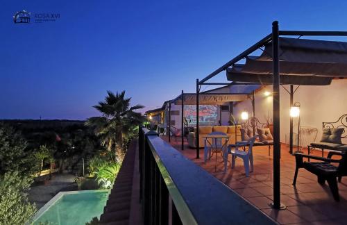 a balcony of a house with a swimming pool at night at ROSA XVI - Garden Guest House in Vilar Torpim