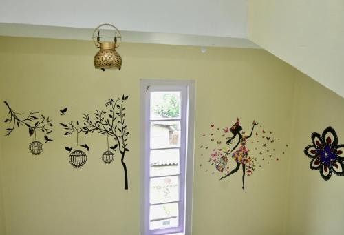 a room with a wall with a girl and a tree on it at Namaskar Lodge and Homestay in Guwahati