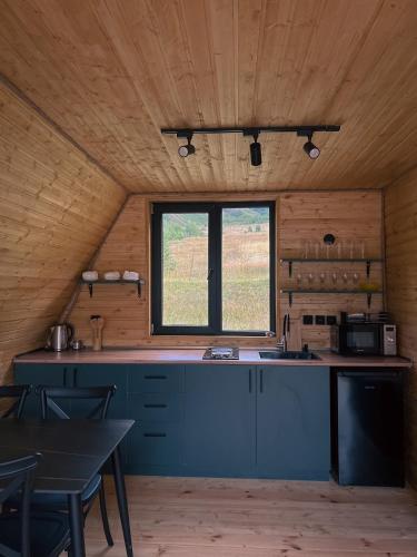 a kitchen with a blue counter and a window at Gagma chalets in Stepantsminda