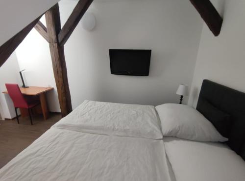 a bedroom with a bed and a tv on the wall at Penzion Na Protivínské in Strakonice