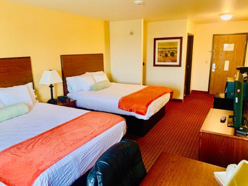 a hotel room with two beds and a table at PARK VIEW INN & SUITES in Hoisington